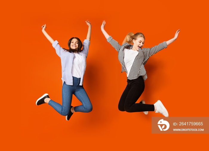 Friendship concept. Cute teen girls jumping in studio