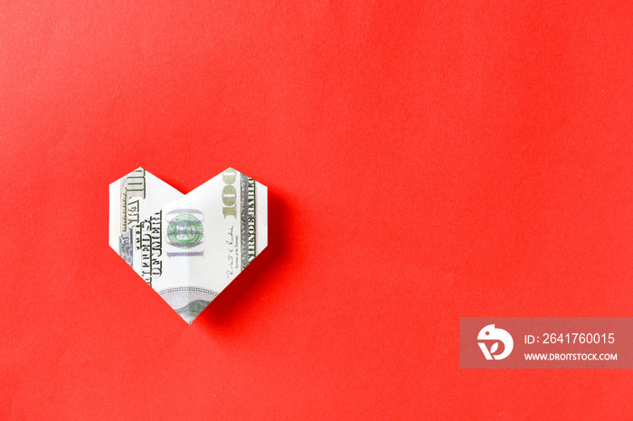 Origami heart made of dollar banknote on color background