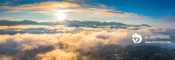 Aerial panoramic view of golden light on morning clouds in blue sky. Flight through moving cloudscap