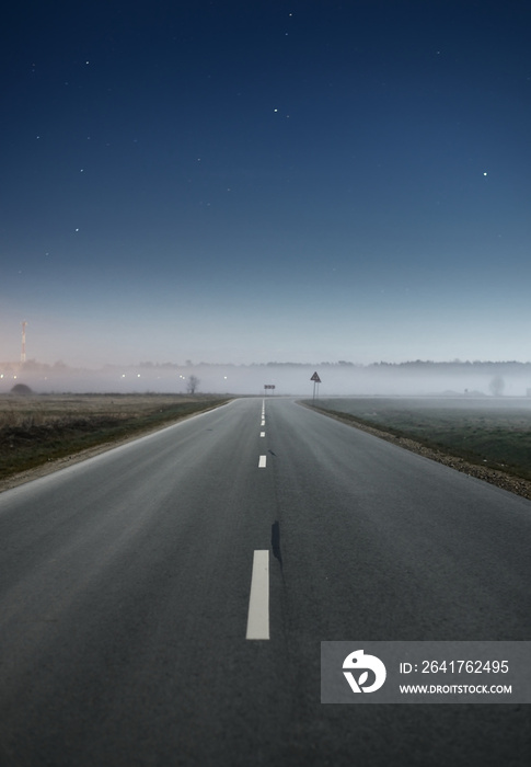 晴朗的蓝色星空，夜晚空旷的高速公路上有雾。大气景观。田园田园风光