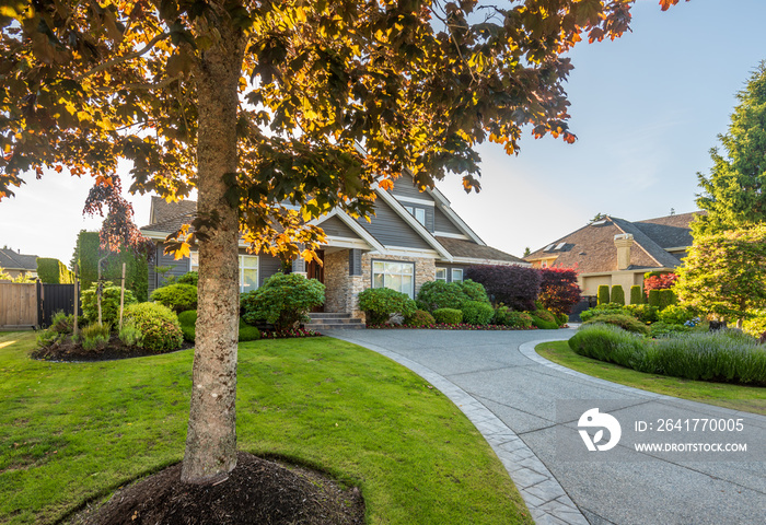 Beautiful exterior of newly built luxury home. Yard with green grass and walkway lead to front entra