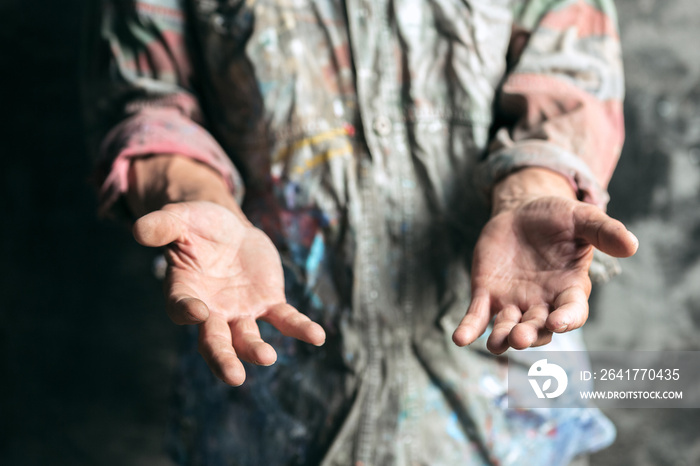 Male beggar hands seeking money, coins from human kindness on the wooden floor at public path way or