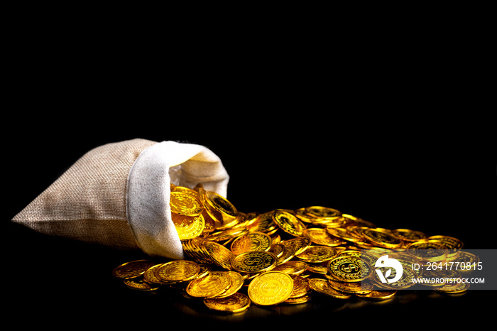 Stacking gold coin in treasure sack on black background