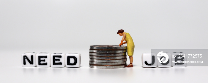 A concept about job shortages. A miniature woman standing with a pile of coins between a NEED text