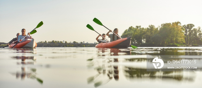 Active friends spending weekend together kayaking in boat on a river on a summer day