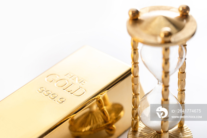 Hourglass and fine gold bullion on white background.