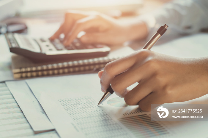 accountant working on desk to using calculator with pen