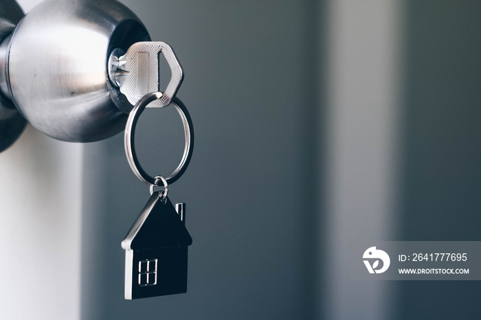 房地产概念，钥匙孔中有金属屋钥匙链的家庭钥匙