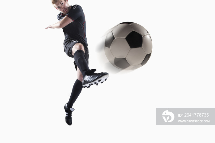 Athlete kicking soccer ball