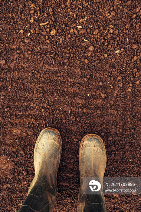 农民橡胶靴在耕地上的俯视图