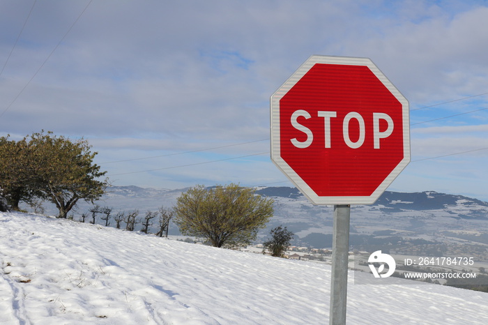 Panneau STOP - panneau de signalisation routière sur fond de paysage enneigé dans le massif du Pilat