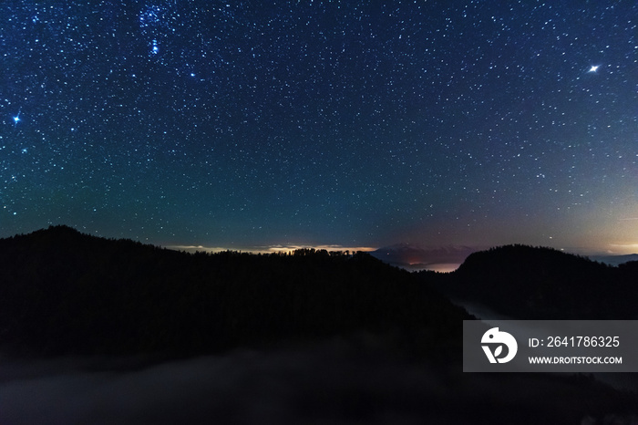 山顶上一个美丽的星空之夜，有美丽的风景和雾。