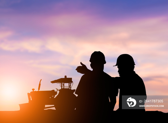 silhouette two men to operate heavy machinery plowed soil in pre