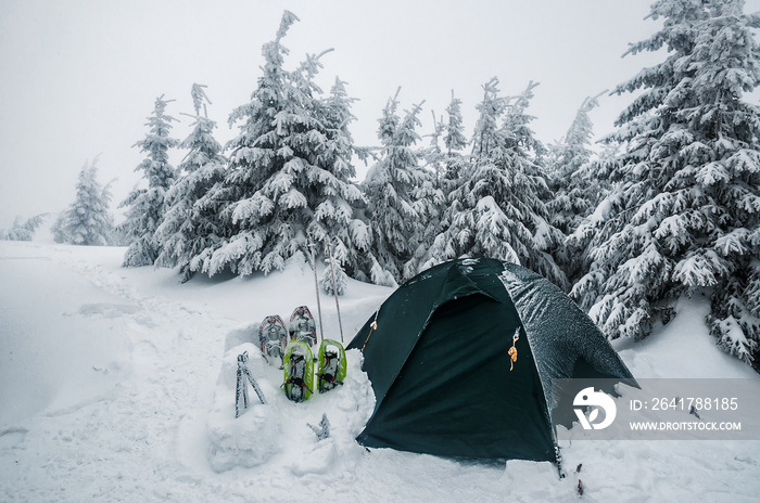 雾蒙蒙的雪山里的帐篷和雪鞋