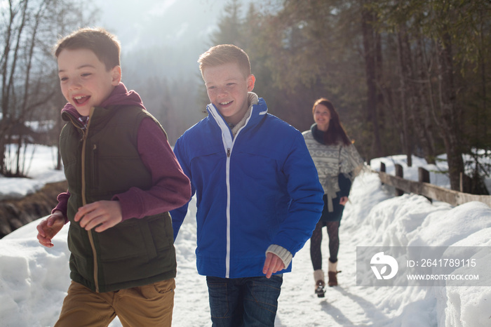 Happy brothers on sunny snowy footpath