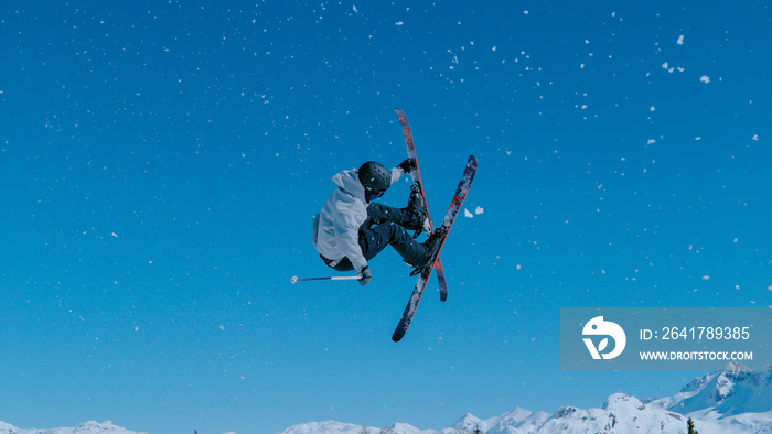 专业的自由式滑雪运动员骑上一个踢球者，做了一个惊险的旋转动作。