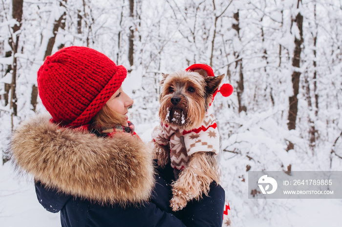 一个女孩和一只狗在冬季森林里的特写肖像。一个女人在鼻涕里和一只宠物玩耍