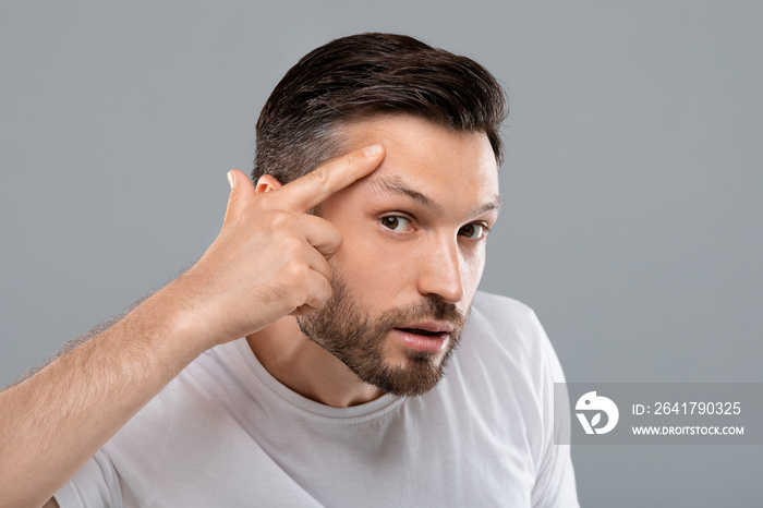 Middle-aged man looking for wrinkles on his face