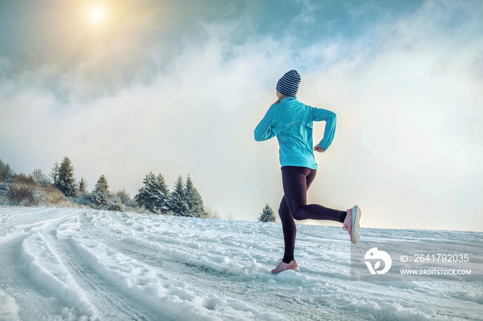 跑步的女人。冬天阳光明媚的雪地上的跑步者。女性fi