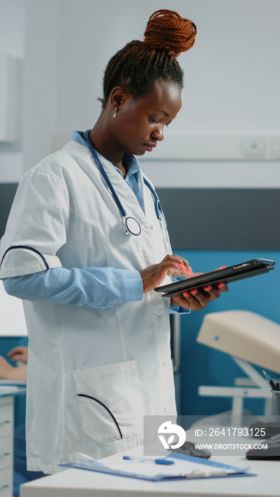 女医生手持带触摸屏的数字平板电脑进行医疗预约。医生工作智慧