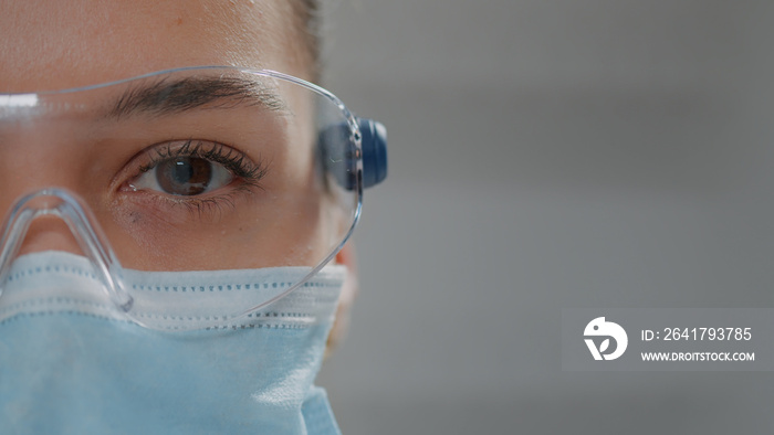 Scientific researcher looking at camera with glasses and face mask for protection. Biochemist wearin