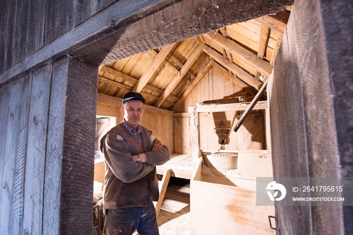 portrait of a miller in retro wooden watermill