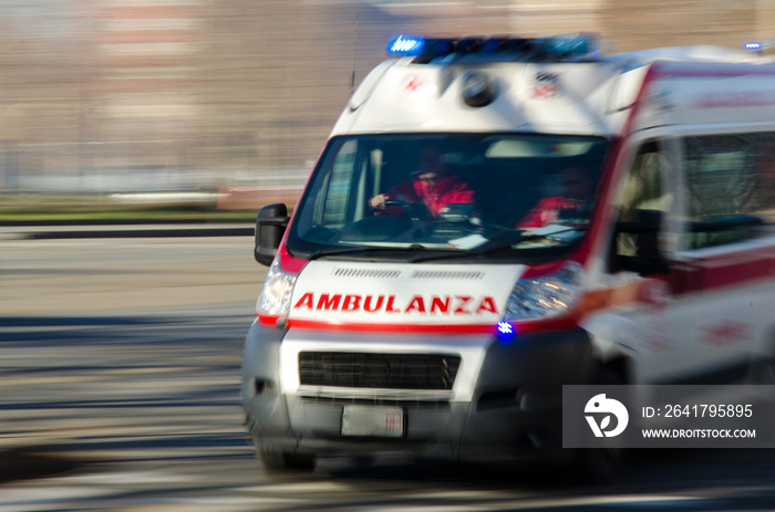 Ambulance in Italy in emergency driving very fast with blue lights to accident scene. Blurred backgr