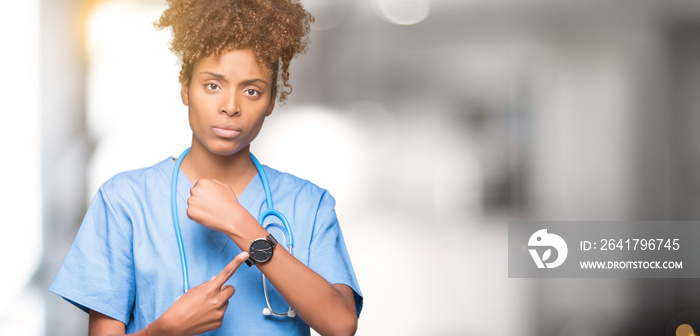 Young african american doctor woman over isolated background In hurry pointing to watch time, impati