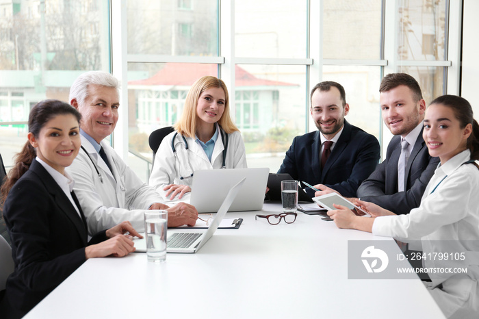 Team of doctors sitting at table in clinic