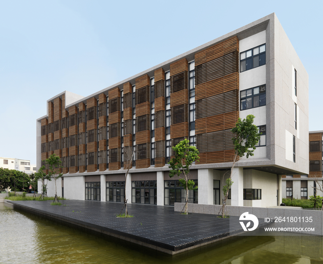 Modern pond in front of commercial building against clear blue sky