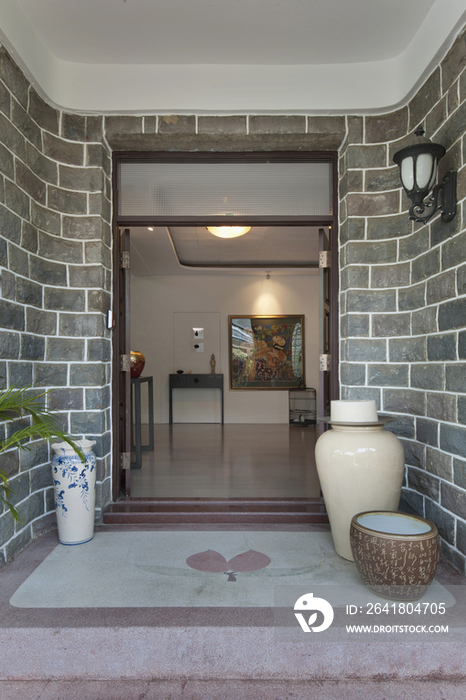 Narrow walkway with gate open and plants at the entrance of a house