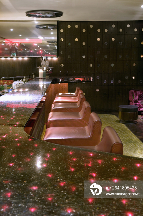 Reflection of red lights on bar counter in restaurant