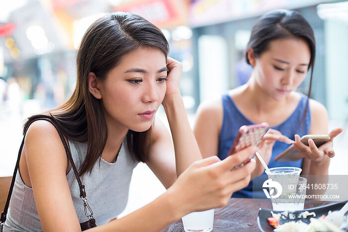 年轻女子在露天咖啡馆使用手机