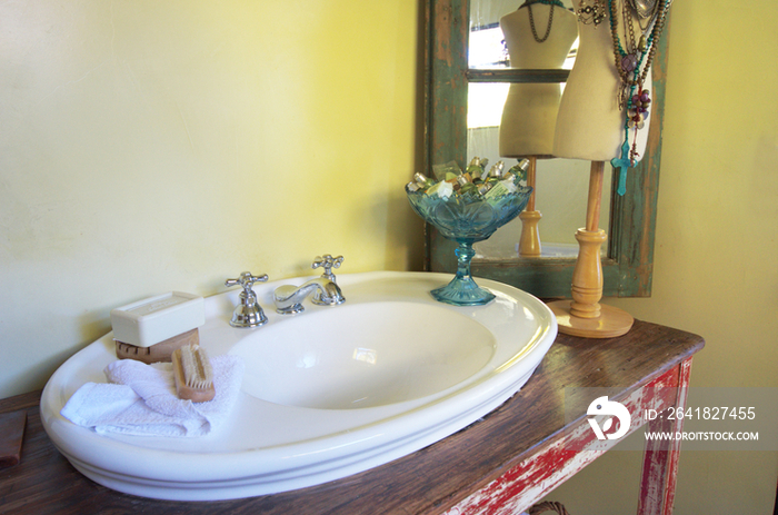 Close-up of washbasin and perfume stand in bathroom