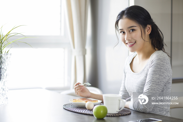 年轻女子在家吃早餐