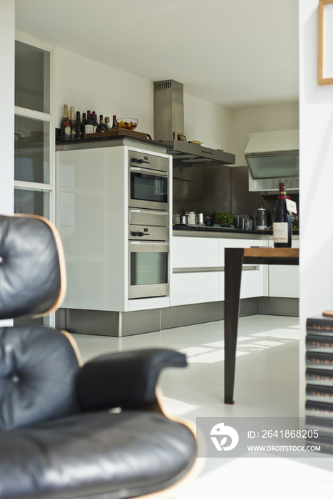 Close-up of a cropped leather armchair with double oven in contemporary kitchen at home