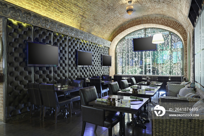 Restaurant interior with TV screens on leather covered wall