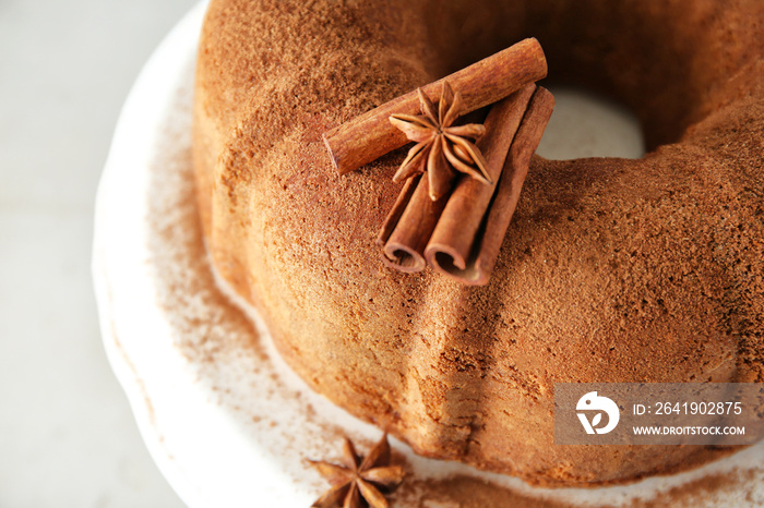 Ceramic stand with delicious cinnamon cake on light background, closeup