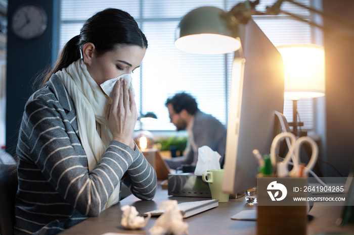 Woman working in the office and having a cold