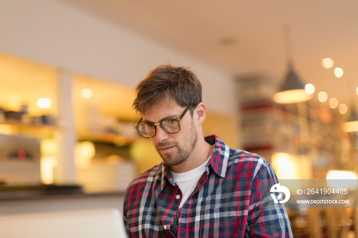 Focused man working at laptop in cafe