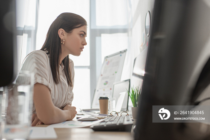 Selective focus of information security analyst working with computers in office