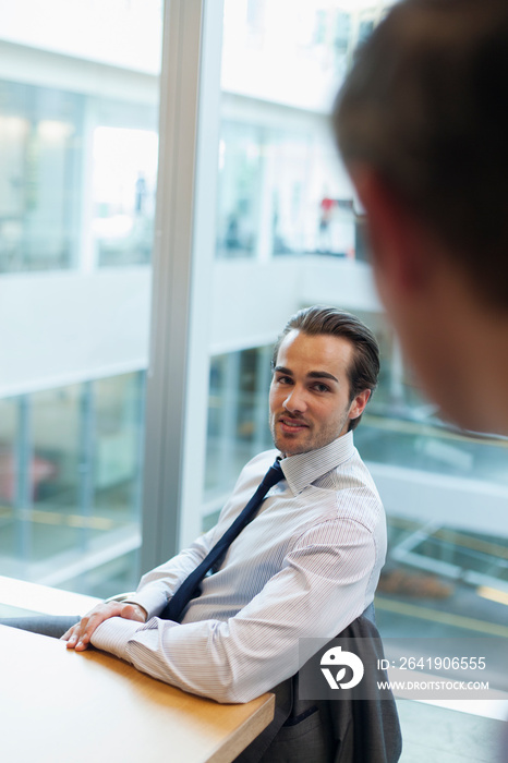 Corporate businessman talking with colleague in office