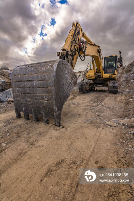 Excavator in a quarry extracting stone