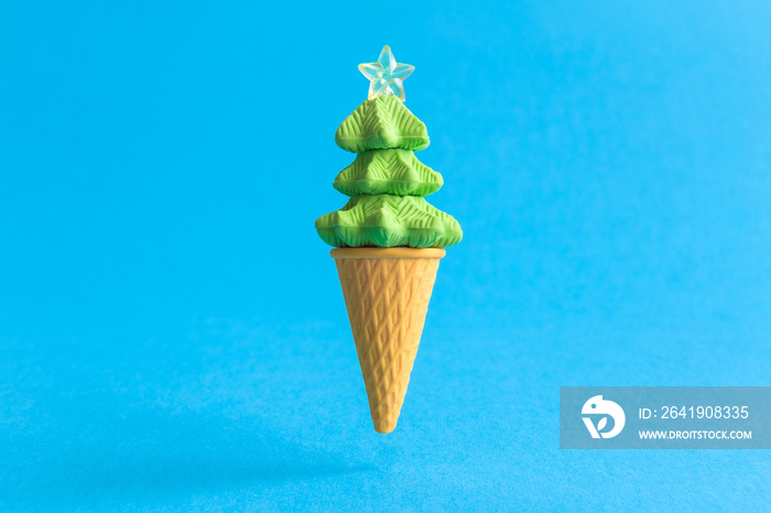 Christmas tree in form of ice cream scoop in cone abstract isolated on blue.