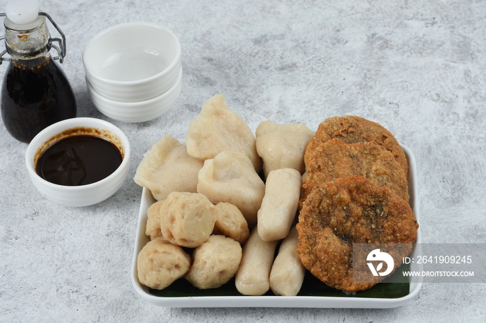 Pempek with cuko sauce in white plate. Pempek or empek-empek is a savoury Indonesian fishcake delica