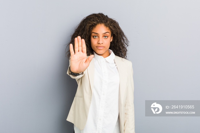 Young african american business woman standing with outstretched hand showing stop sign, preventing 