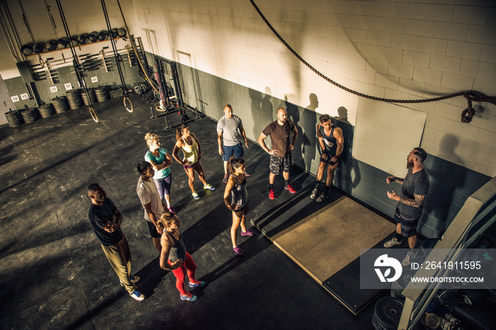 Trainer talking to fitness group in gym