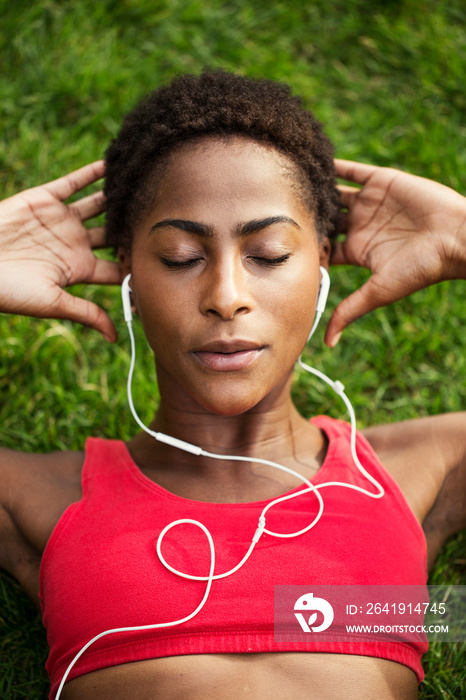 Close up of woman wearing earphones exercising in park