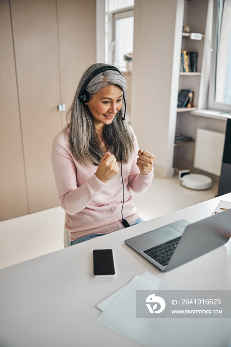 Adult beautiful female sign language tutor participating in online training from school office