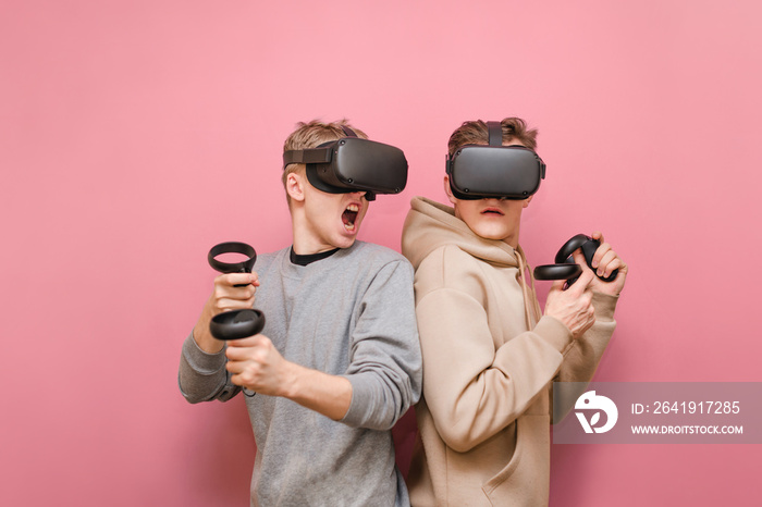 两个戴着VR头盔的情绪激动的年轻人在虚拟现实游戏中比赛。两个玩虚拟现实的玩家